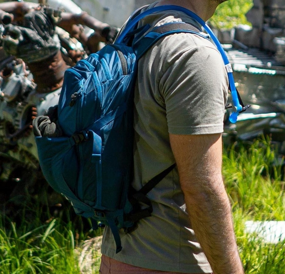 Reviewer wearing blue backpack outside