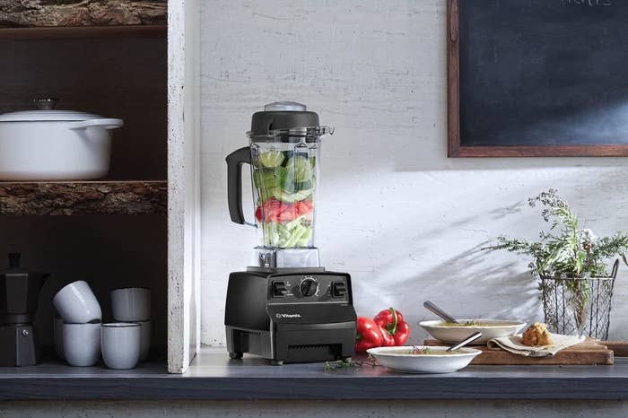 The large blender full of veggies on a countertop
