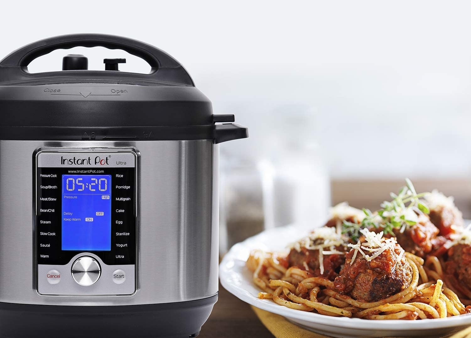 The Instant pot next to a bowl of spaghetti