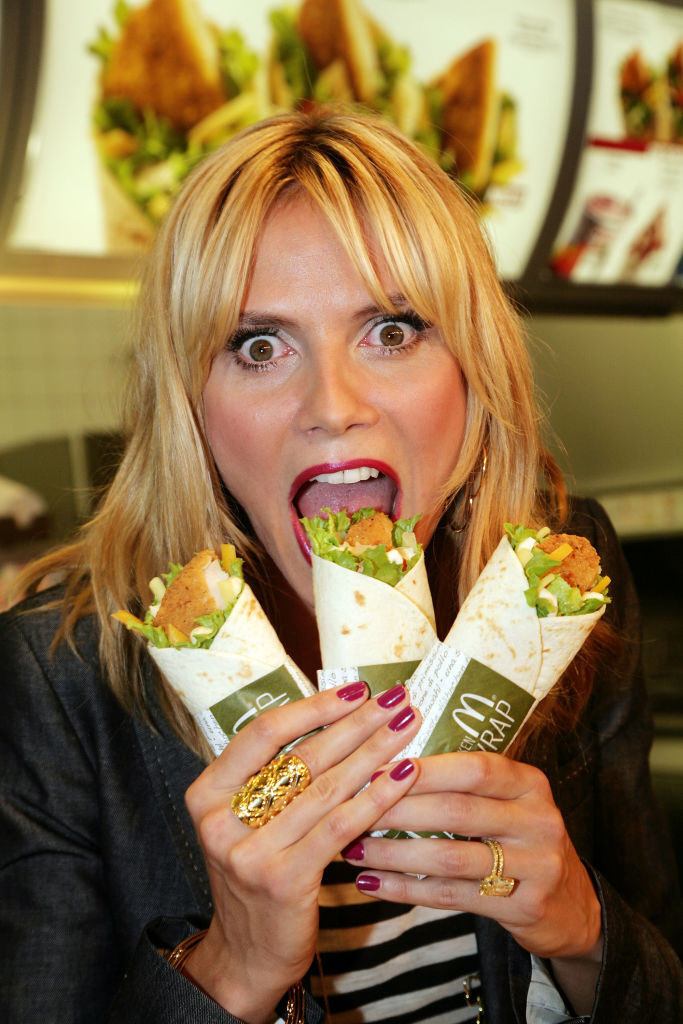 Heidi Klum pretending to bite into three McDonald&#x27;s Snack Wraps
