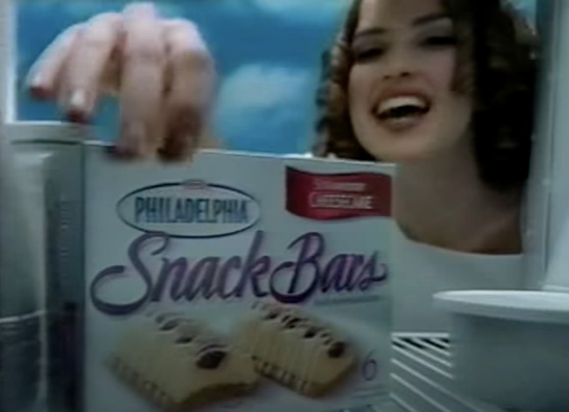 Screenshot of Snack Bar commercial, with an angel reaching into the fridge for Snack Bars