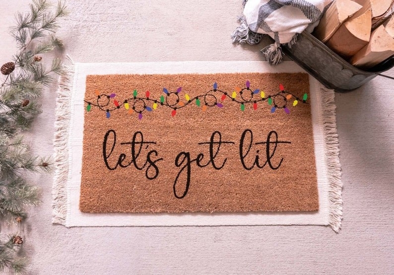 doormat with colorful Christmas lights that says &quot;let&#x27;s get lit&quot; underneath