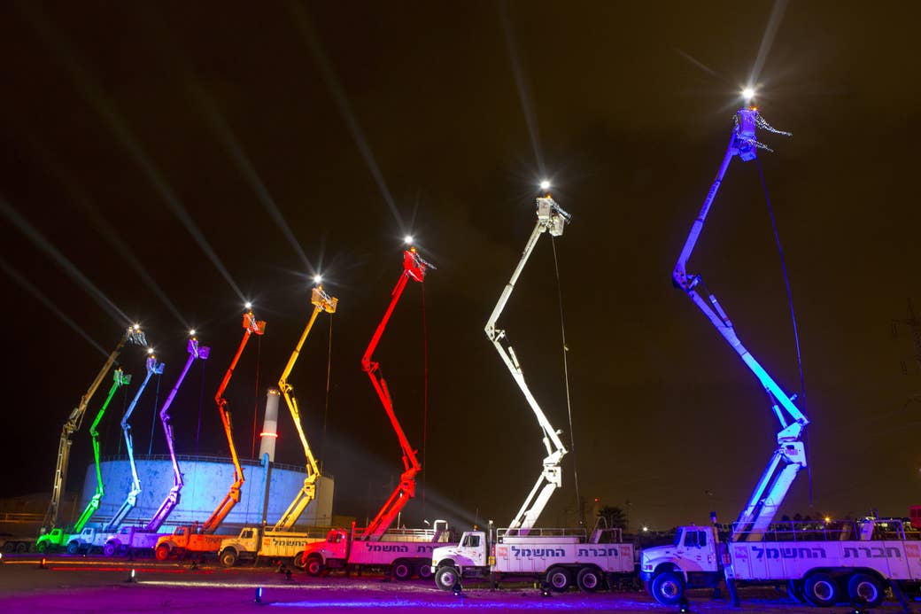 A bunch of trucks with their ladders raised as menorahs