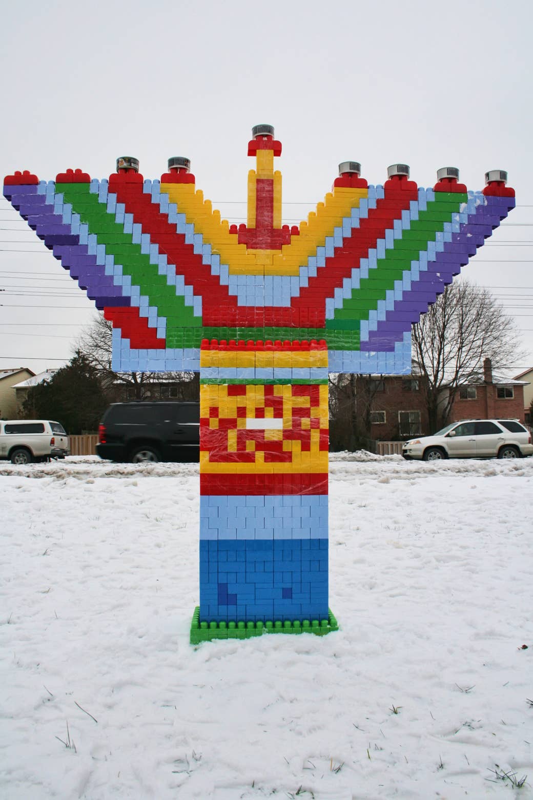 a giant menorah made of colorful blocks in the snow