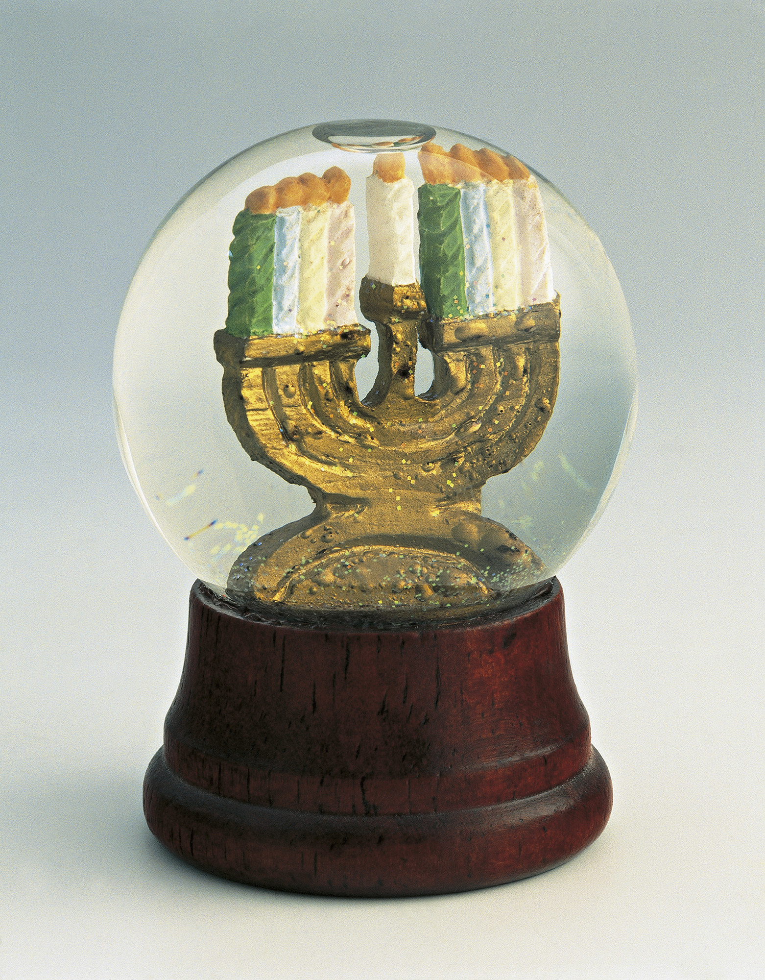 A snow globe with a menorah inside, on a white background