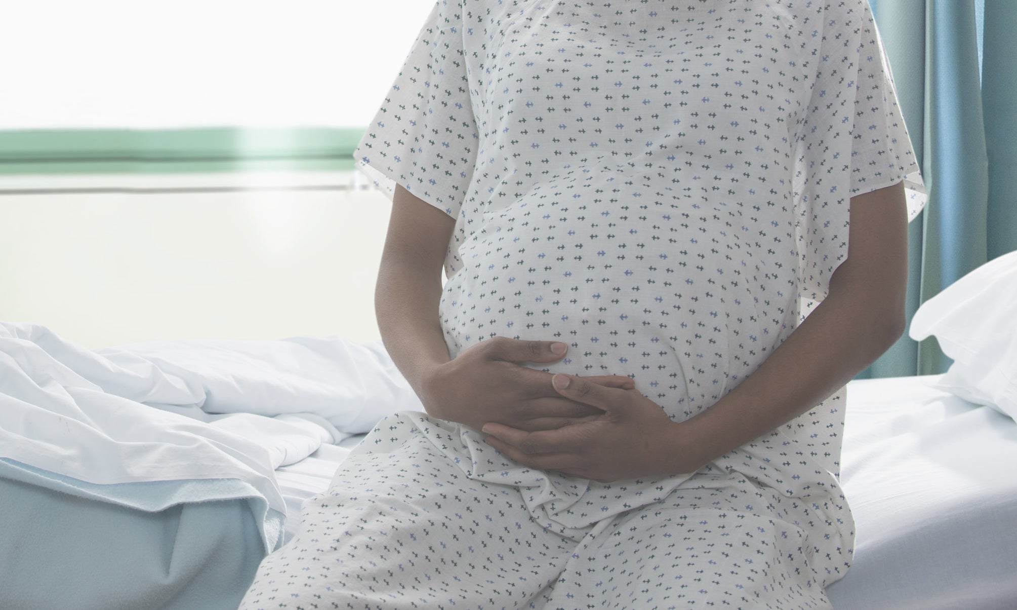 pregnant woman in a hospital gown on a hospital bed