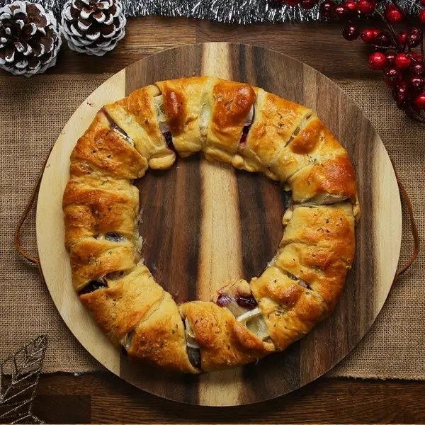 The cranberry and brie crescent ring on a wooden platter.