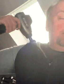Reviewer using massage gun on neck