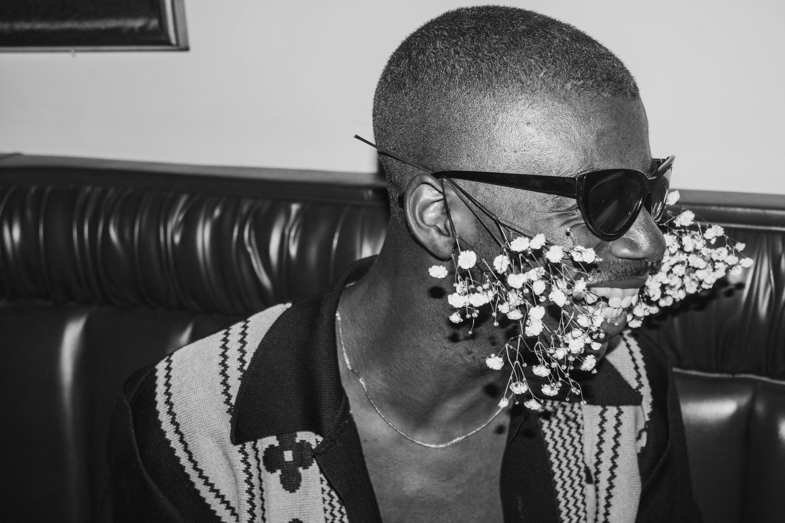 A man wearing sunglasses and flowers on his face