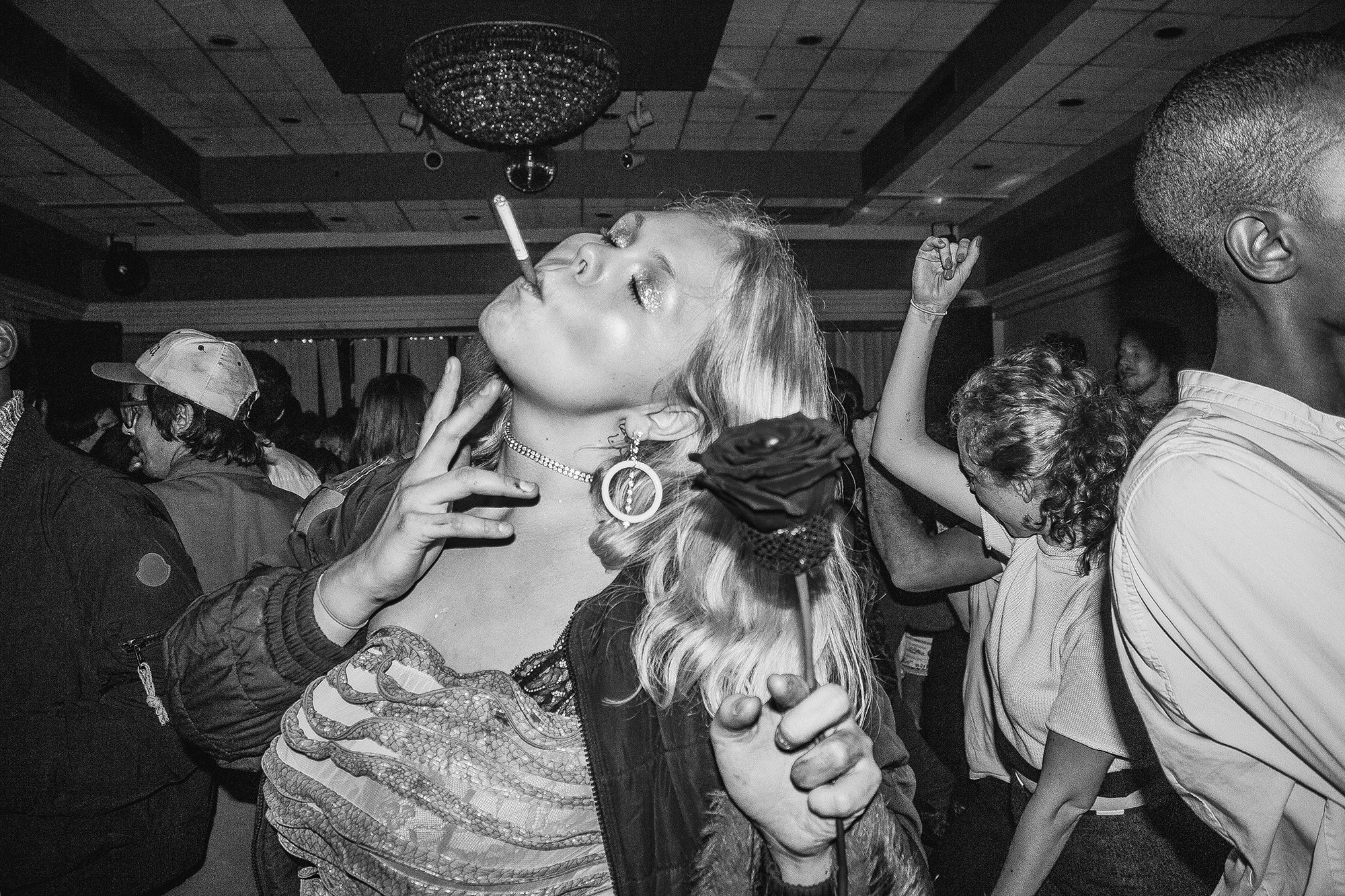 A woman smoking a cigarette while dancing on a dance floor