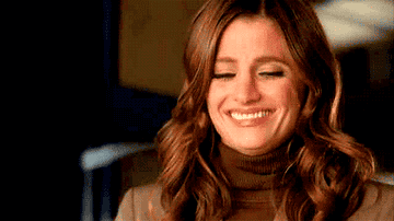 Kate giggling and putting her hand to her mouth on Castle