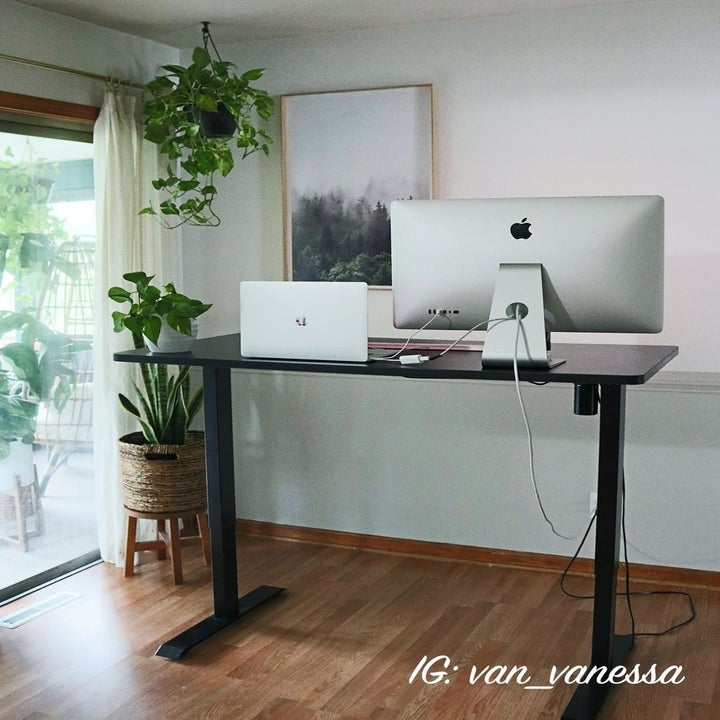 same reviewer showing how the desk adjusts to be a standing desk