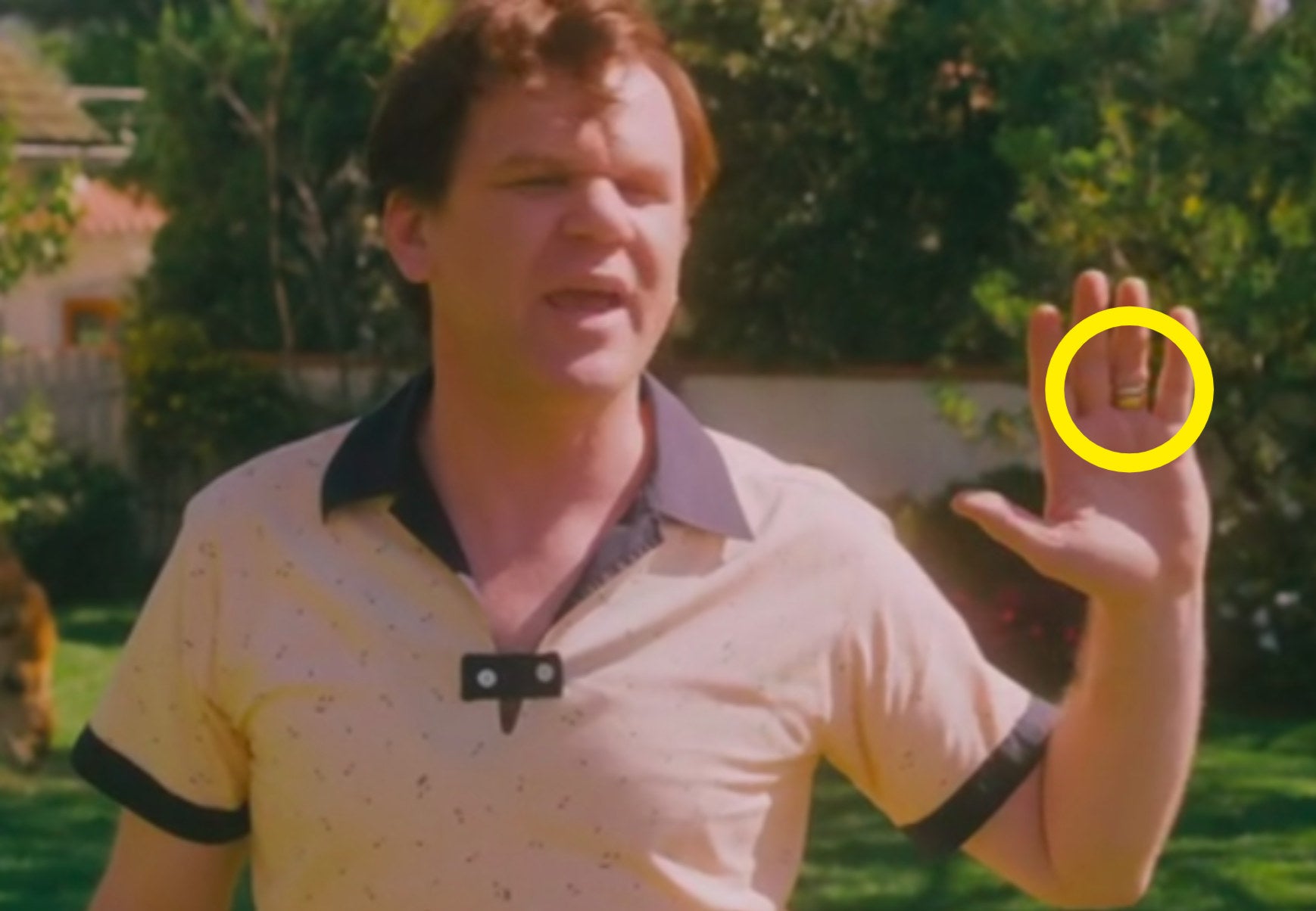 Dewey Cox with his hand up wearing two rings
