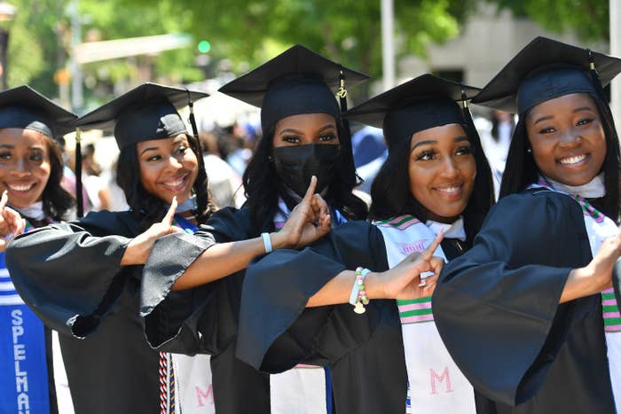 Women posing in their graduation cap and gown alongside each other