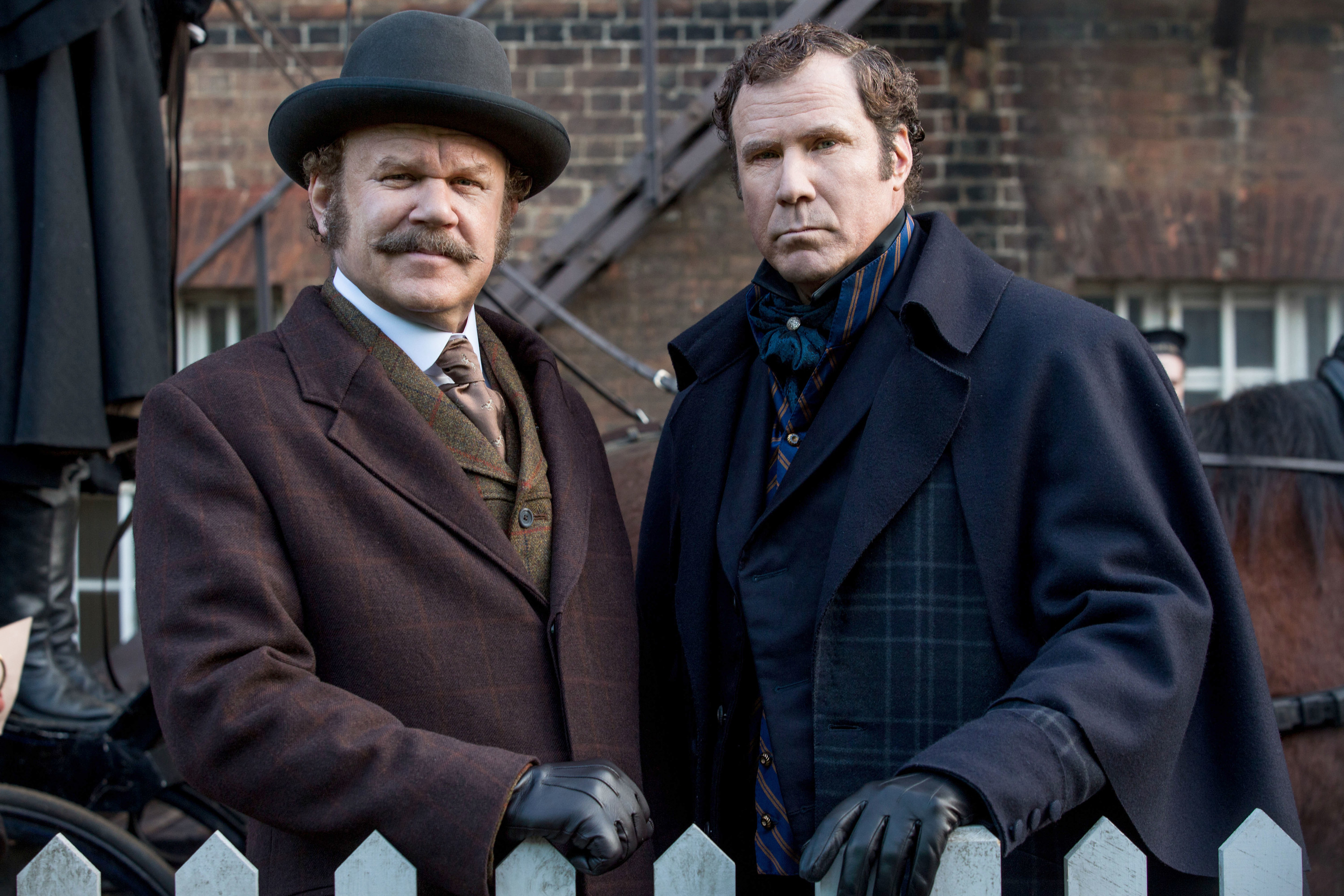John C. Reilly and Will Ferrell lean on a fence