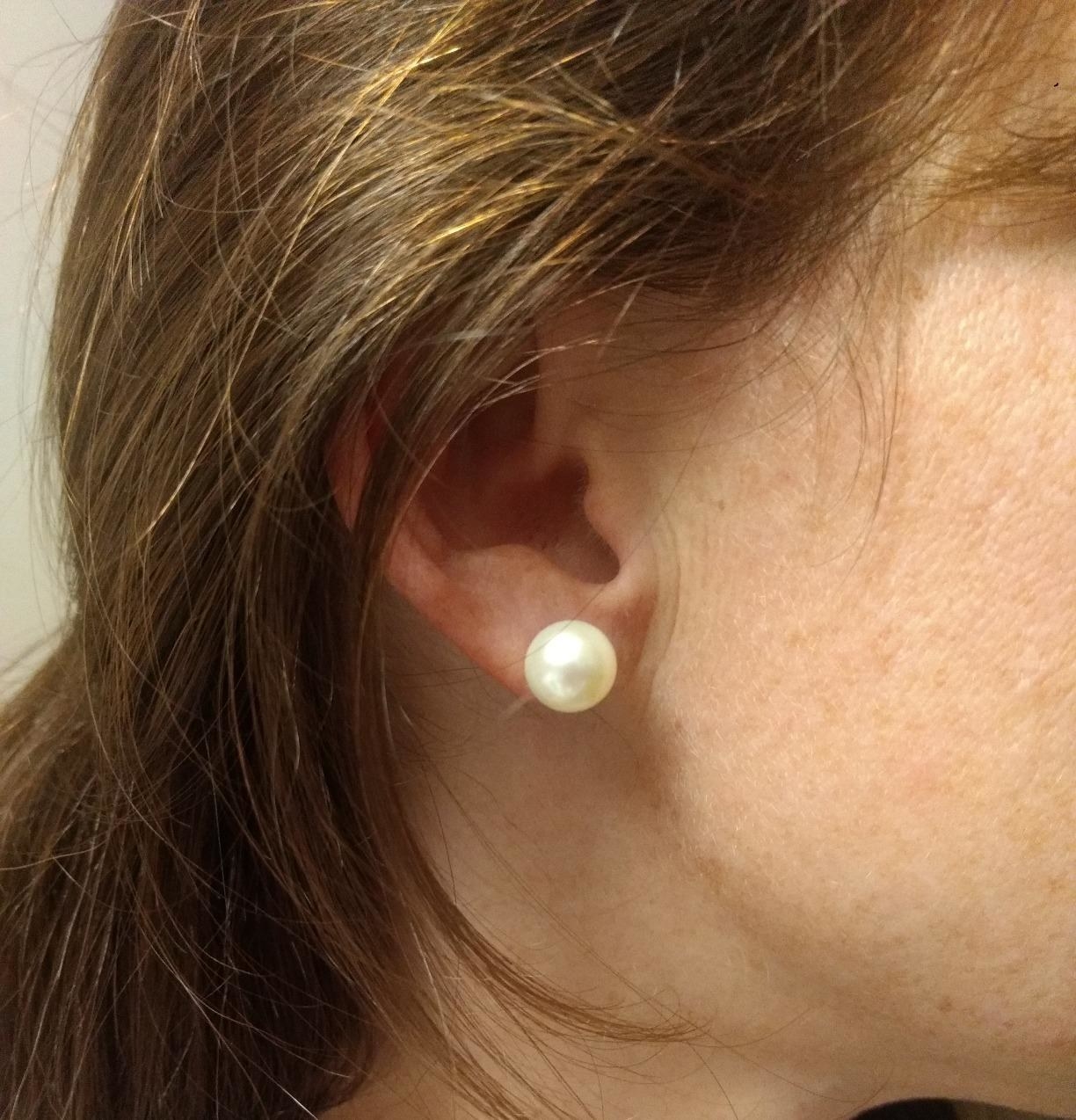 a reviewer wearing a large pearl earring