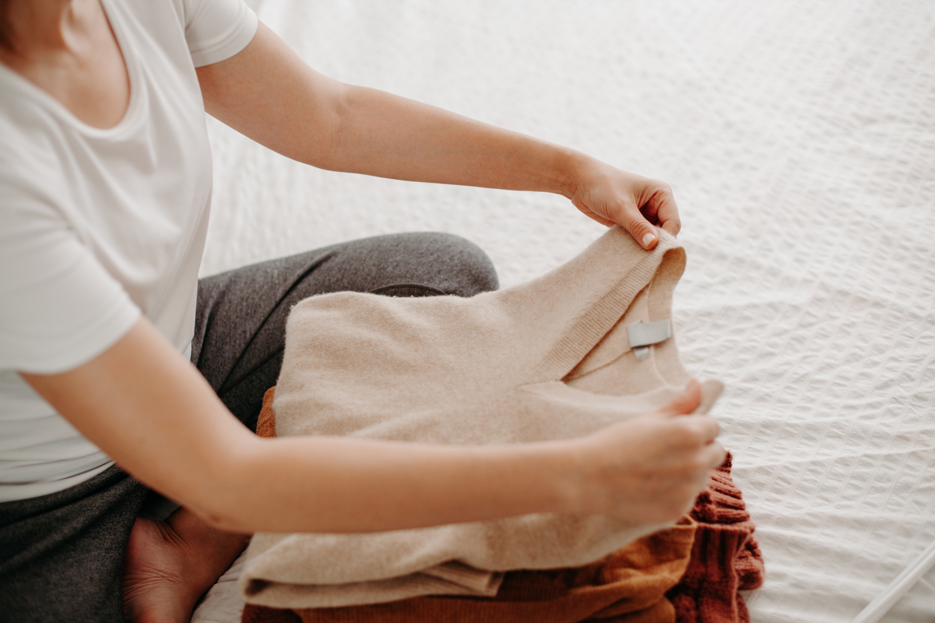 Hands folding a pile of clothes