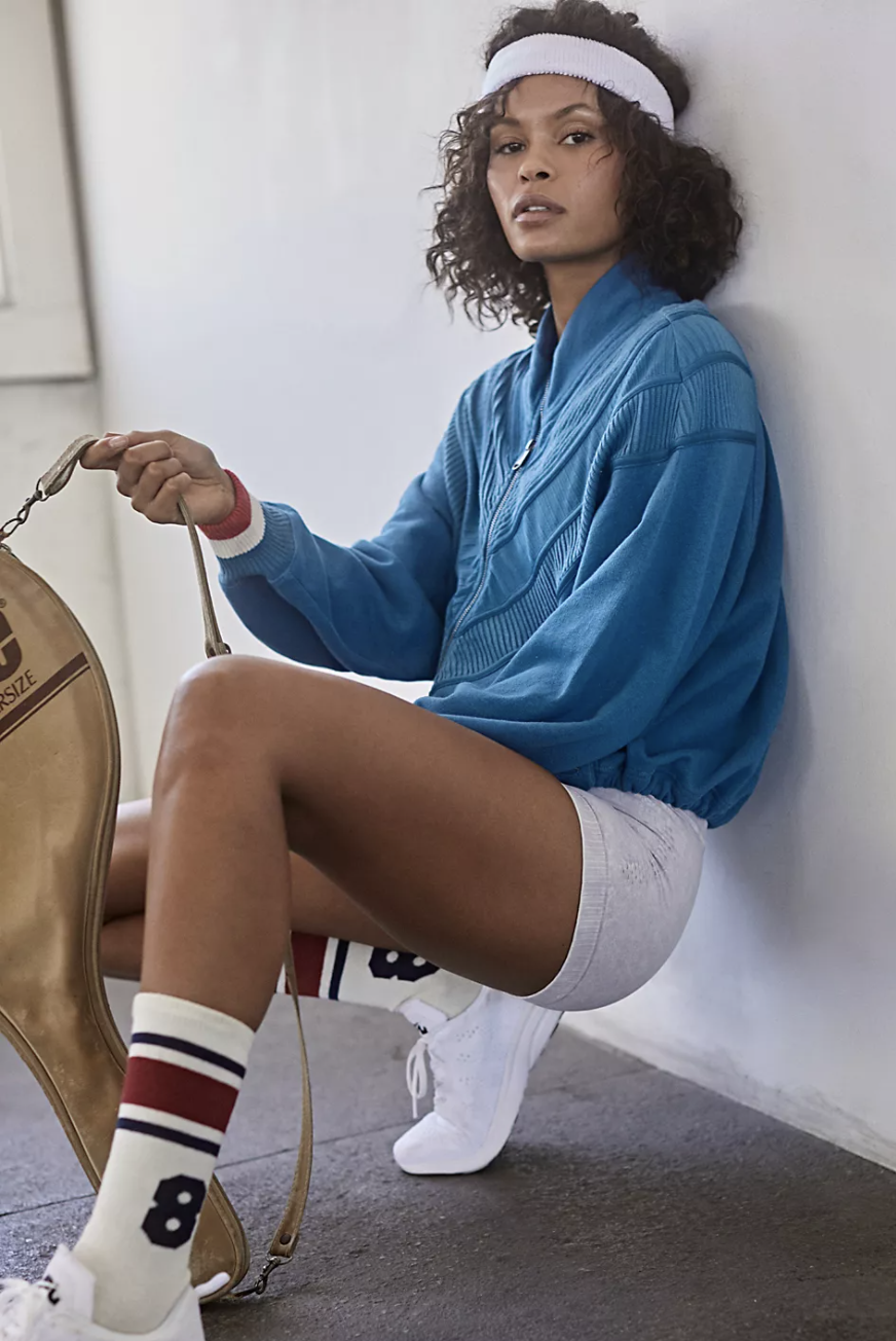 a model in a blue track jacket