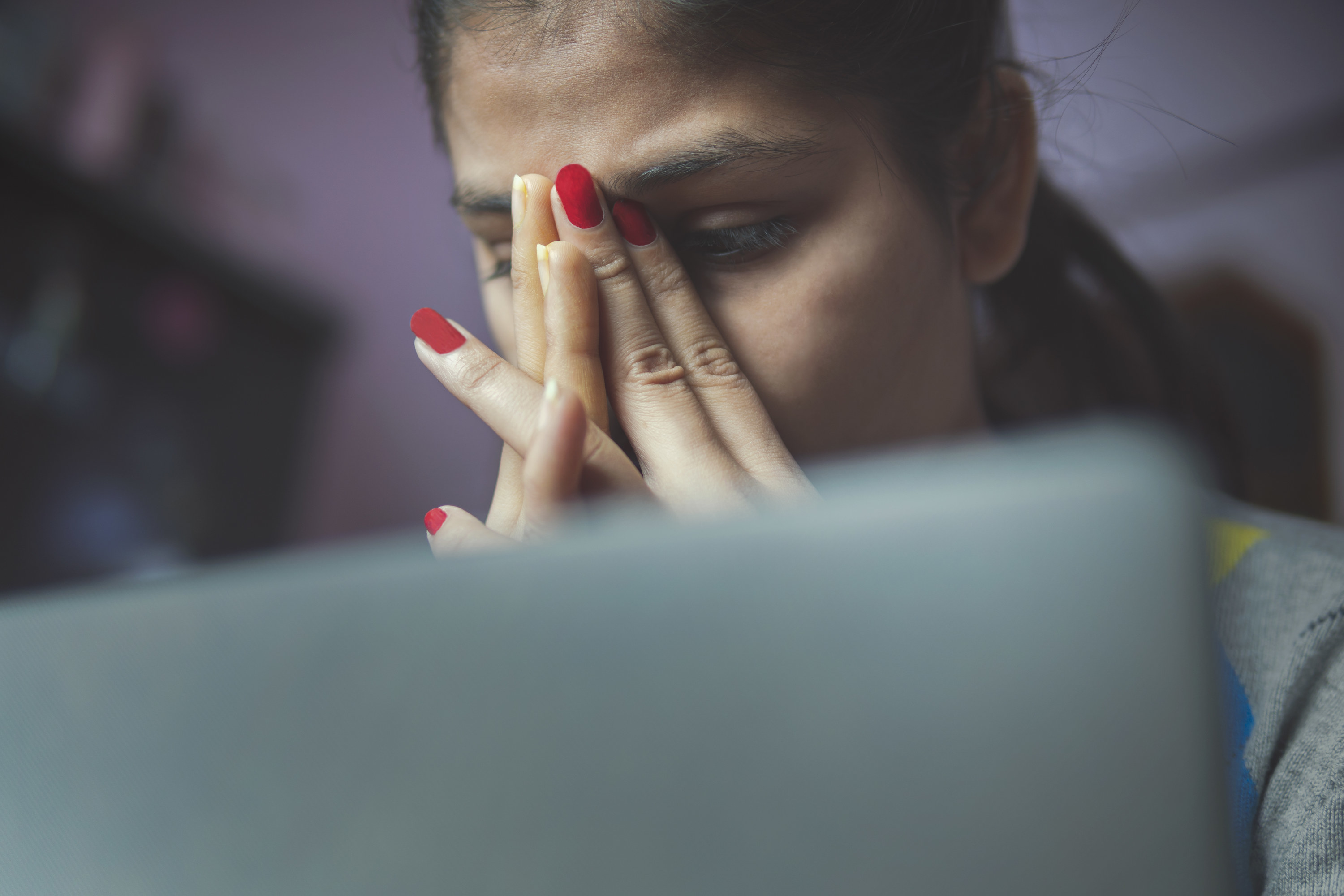 A girl looking upset in front of her laptop