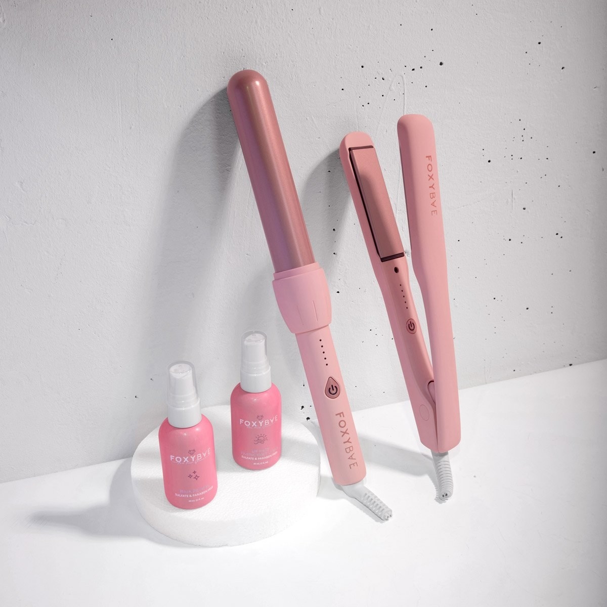 The Classic Holiday Gift Set with pink flat iron, pink curling wand, heat protectant spray, and hair primer in bottles