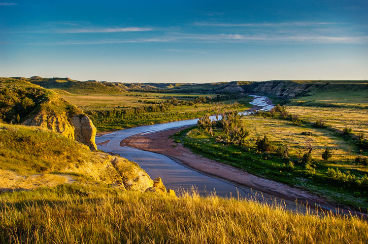 Shot of a North Dakota plateau and a winding road during golden hour