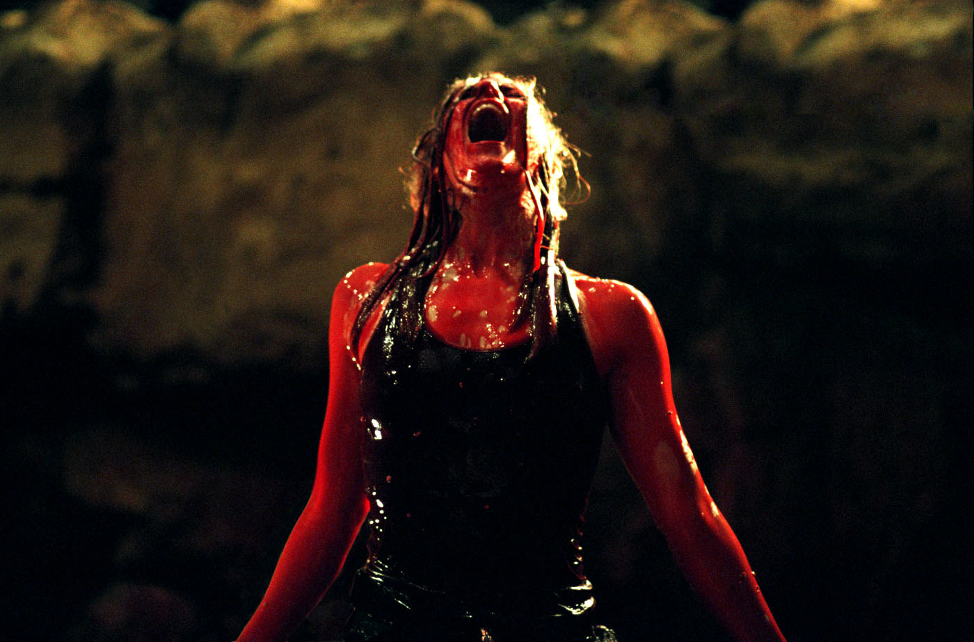 Shauna Macdonald as Sarah, screaming up at the sky covered in blood