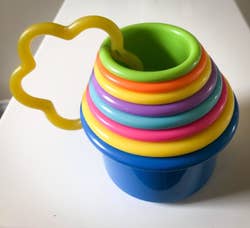 reviewer's photo showing the colorful cups nested inside each other and held together with a star shaped holder