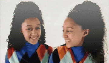 Tia and Tamera in the theme song look at each other, smiling and pointing.