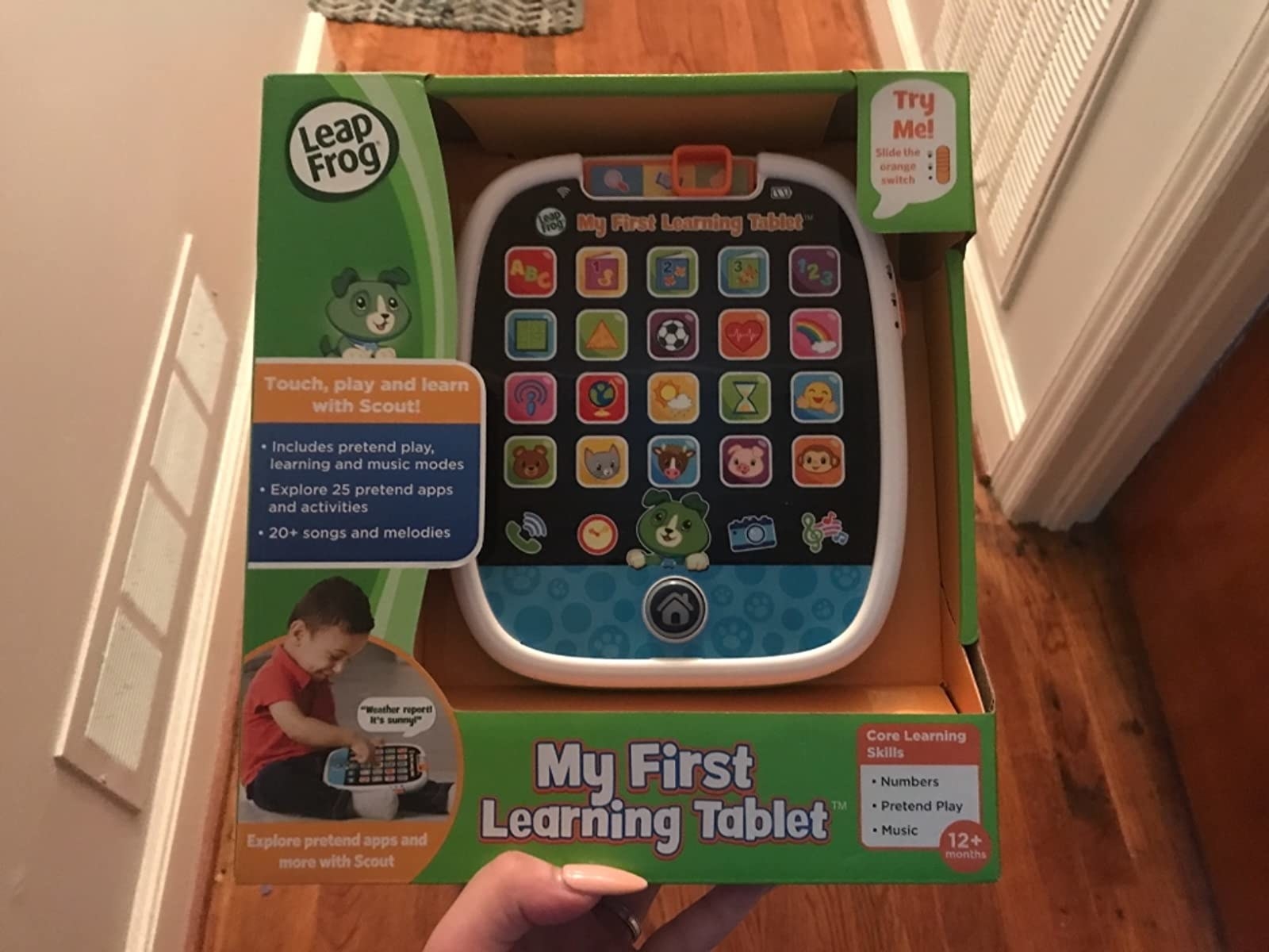 Reviewer holding green box with multicolored children&#x27;s tablet