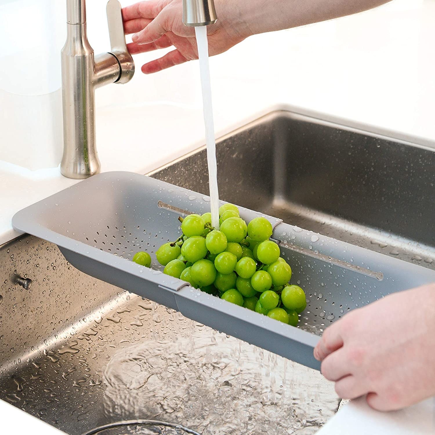 model washing grapes in the over sink colander