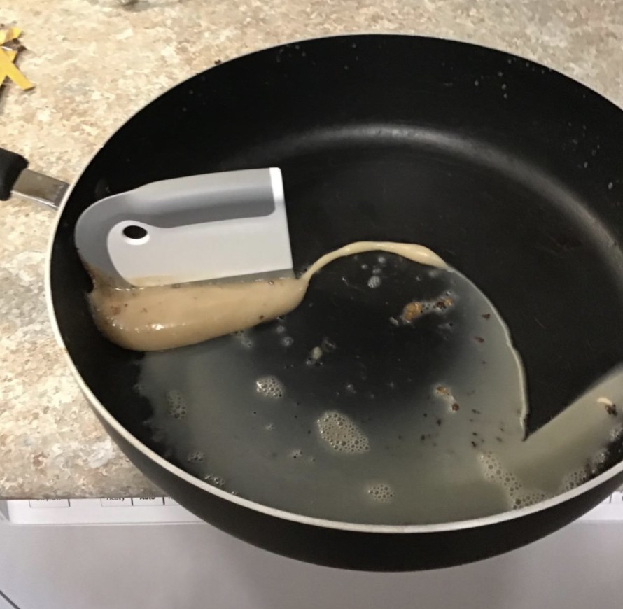reviewer photo showing the oxo scraper completely clearing their pan of grease