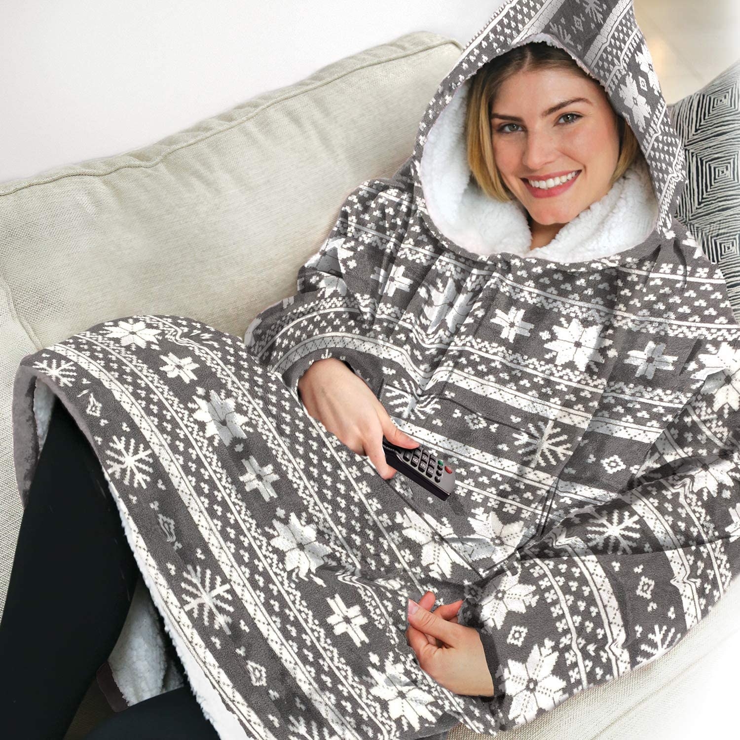 a smiling person wearing the hooded blanket