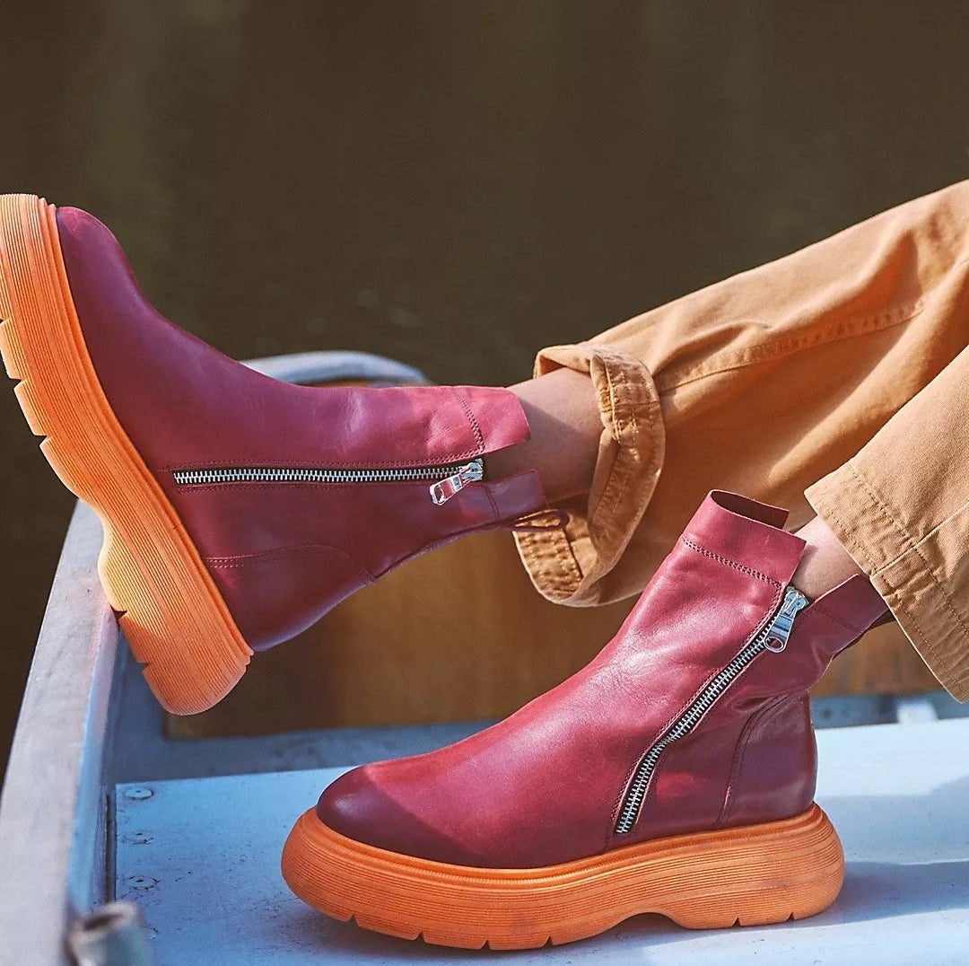 cushy boots with a large orange sole and red top. the sides zip up.