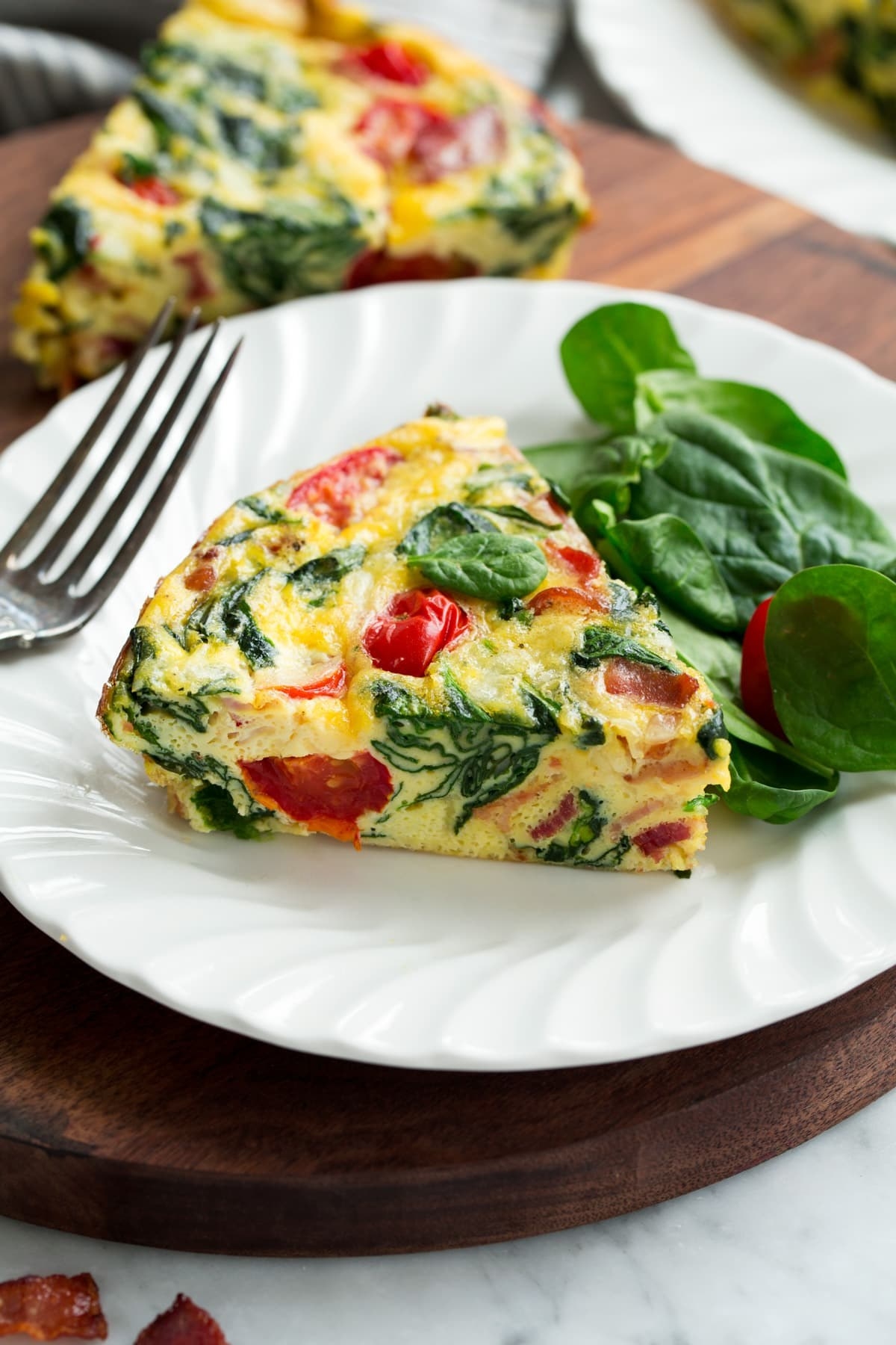 A frittata with spinach, tomato, and bacon.
