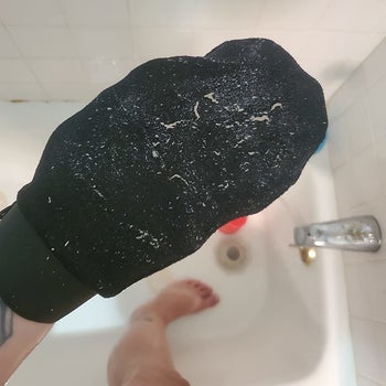 a reviewer photo of the mitt covered in dead skin