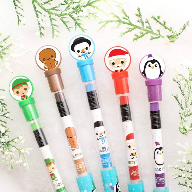 five pencils with an elf, gingerbread man, snowman, santa, and penguin designs