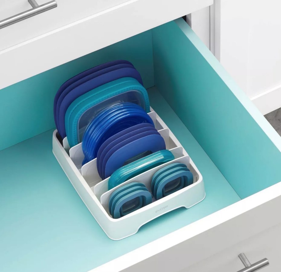 A white container lid organizer in a kitchen drawer