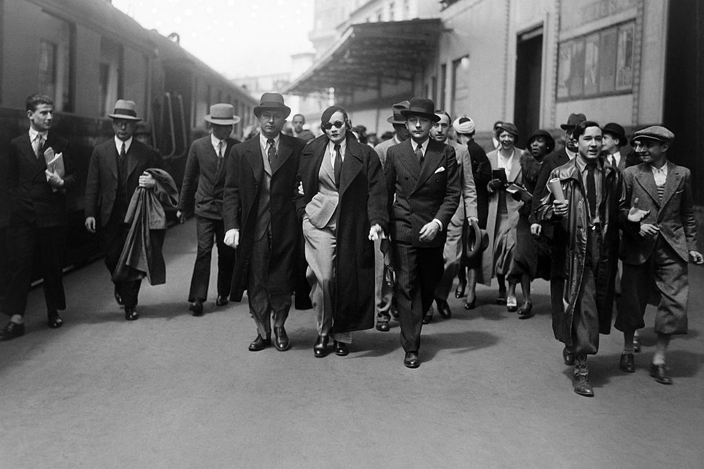 Marlene Dietrich walking with a group of people around her