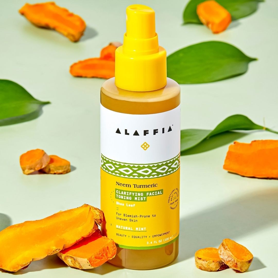 a bottle of the facial spray next to bits of solid turmeric
