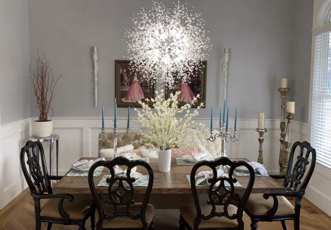 dining room with the chandelier glowing a cool light above the table