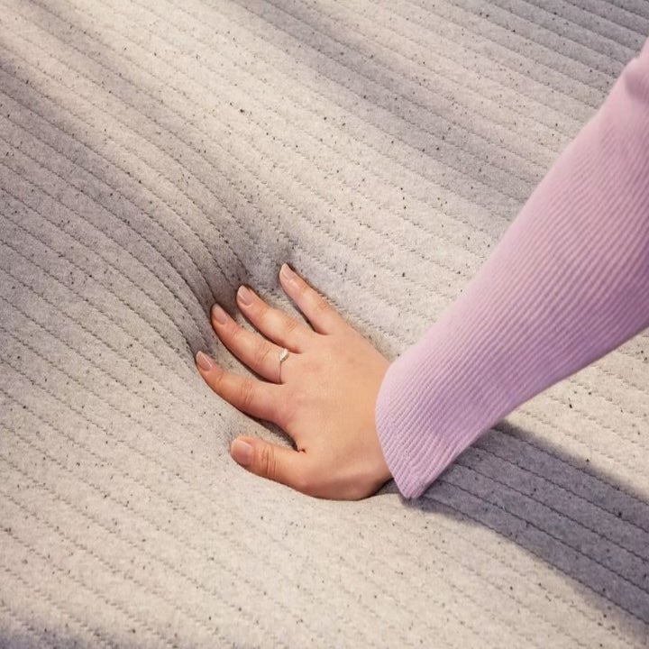 A model pressing their hand into the Casper mattress