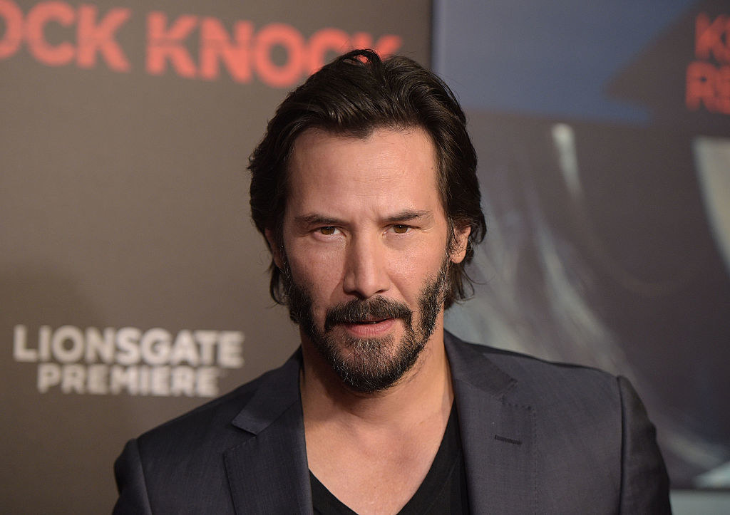 Keanu Reeves on the red carpet looking intensely at the camera