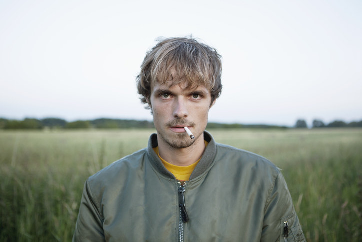 A creepy skinny guy with a cigarette in his mouth