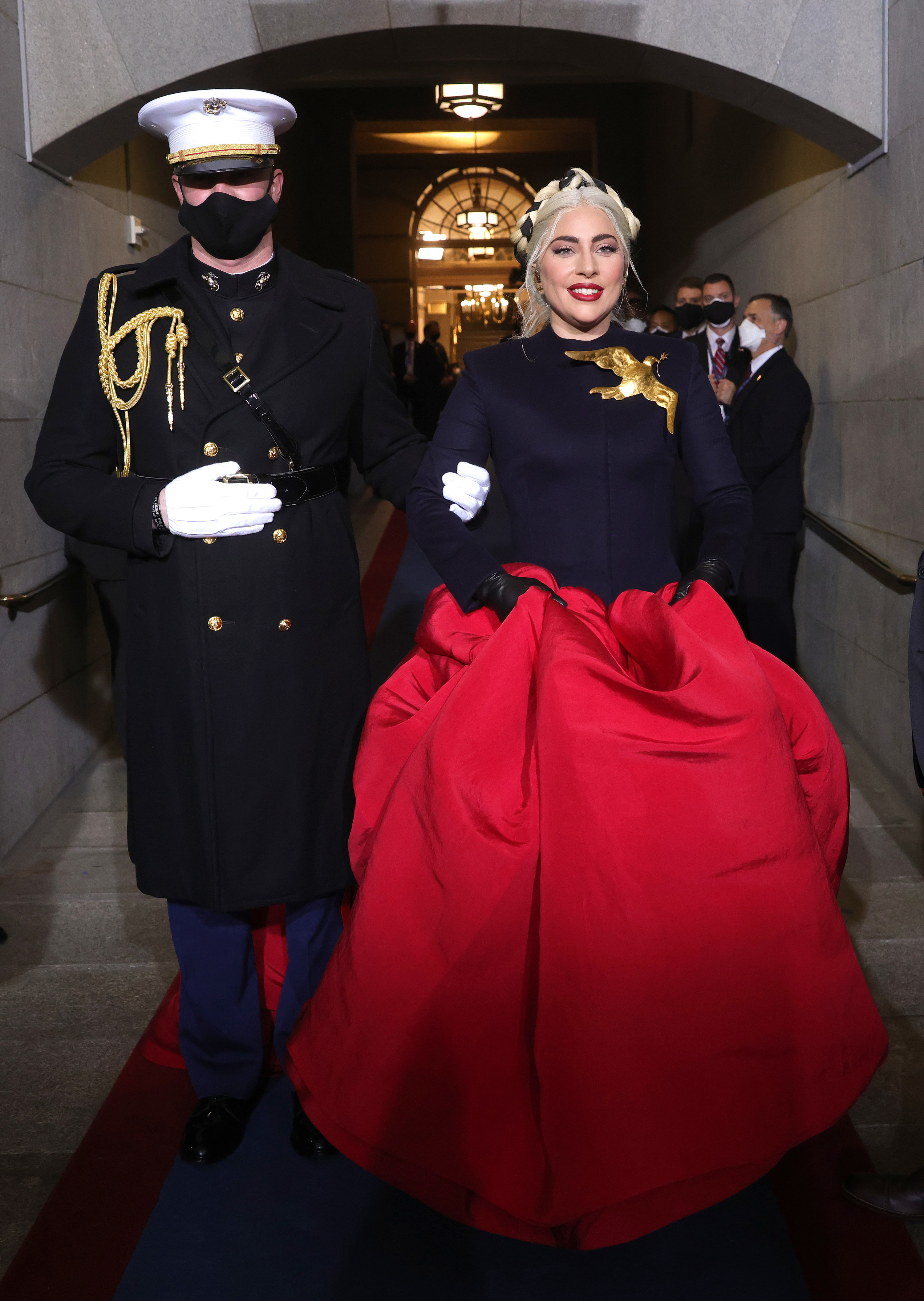 Gaga being escorted to the inauguration podium to perform the national anthem