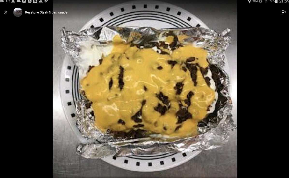 Messy ravioli dish, covered in gross cheese, burned on tin foil