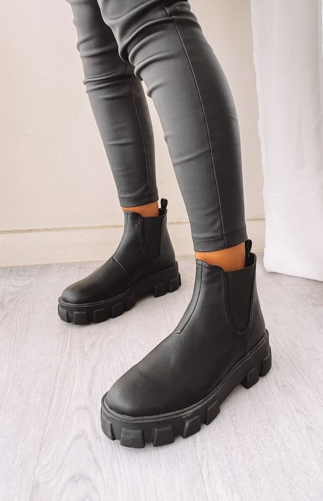 a model wearing the black rubber boots