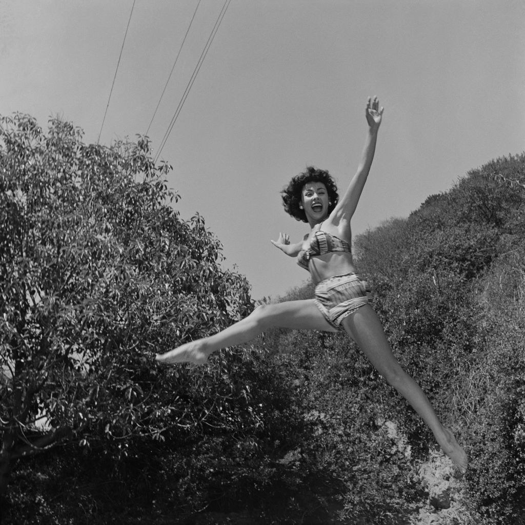 Rita Moreno jumping in the air smiling