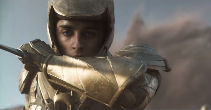 Paul with blue eyes, a knife, and golden armor in &quot;Dune&quot;