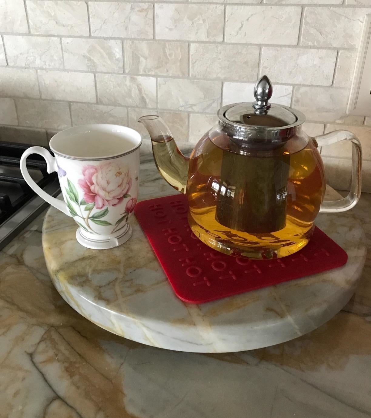 Reviewer photo of the glass tea kettle with tea inside next to a cup