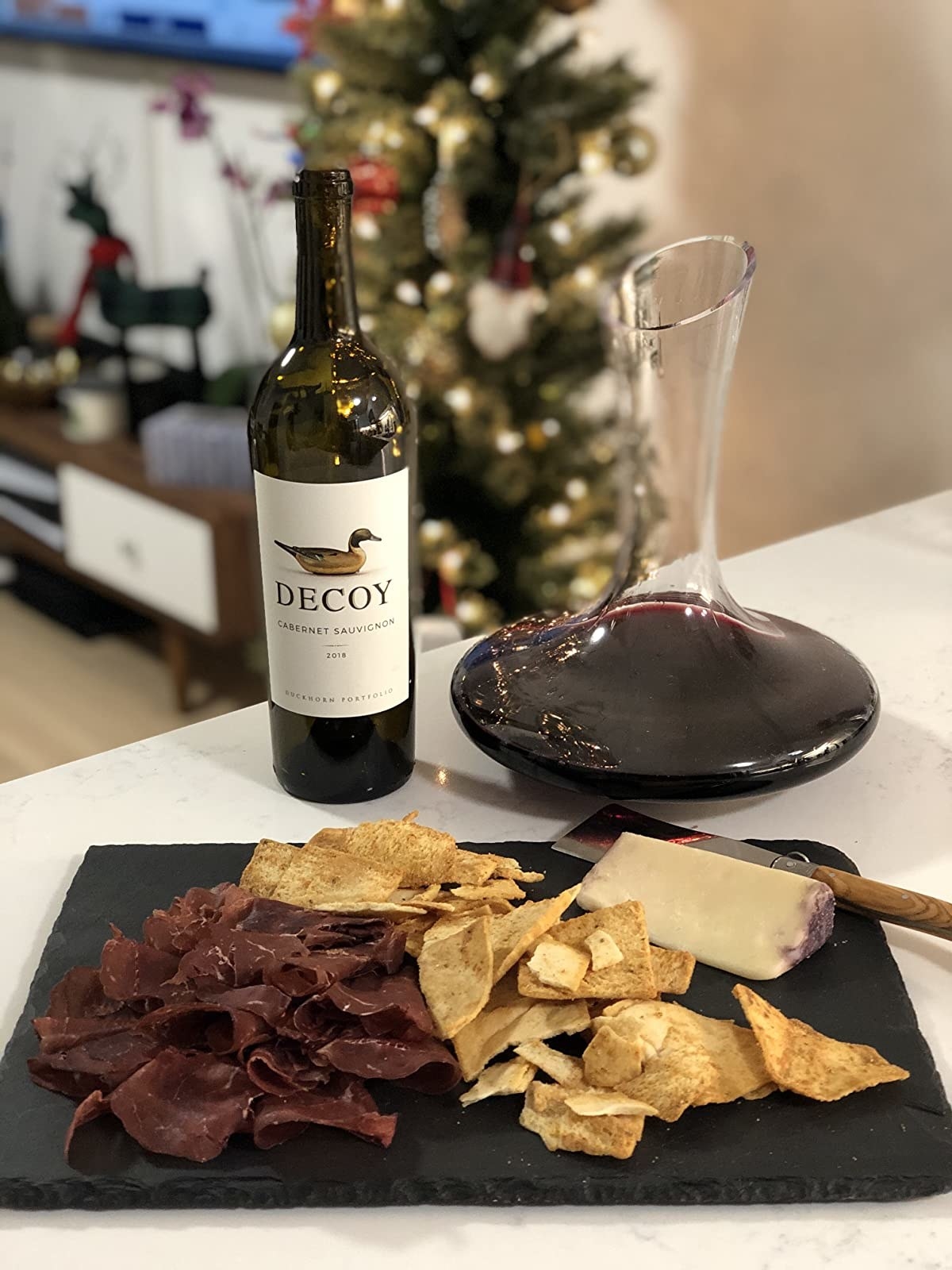 Reviewer photo of the glass decanter next to a plate of cheese and meats